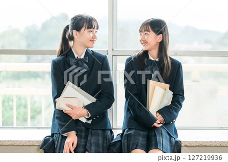 学校の教室で会話する小学生,中学生の女子生徒 学校の教室で会話する小学生,中学生の女子生徒 127219936