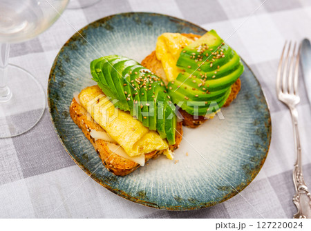 Toasts with avocado cheese and scrambled eggs 127220024