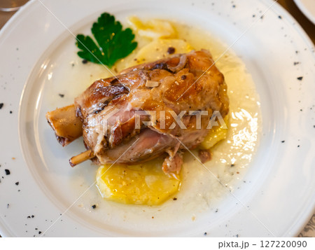 Stewed knuckle with potato served in a plate 127220090