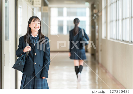 学校の廊下を歩く制服姿の小学生,中学生,高校生の女子生徒 127220485