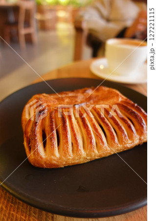 A Delicious Pastry Beautifully Plated on a Rustic Plate Next to Coffee A Delicious Pastry Beautifully Plated on a Rustic Plate Next to Coffee 127221115