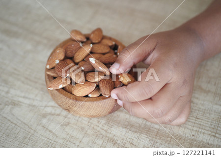 Close up of child hand pick almond nut Close up of child hand pick almond nut 127221141
