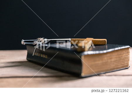 Religious belief concept Close up prayer Christian church service Bible Holy cross Spiritual power Blurred background Desk copy space Heaven God Catholic faith Praise book Jesus worship Gospel symbols 127221162