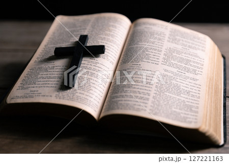 Religious belief concept Close up prayer Christian church service Bible Holy cross Spiritual power Blurred background Desk copy space Heaven God Catholic faith Praise book Jesus worship Gospel symbols 127221163