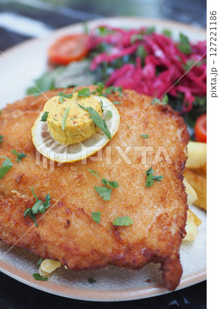 A Tastily Prepared and Deliciously Fried Fish with Lemon and Garnishes A Tastily Prepared and Deliciously Fried Fish with Lemon and Garnishes 127221186