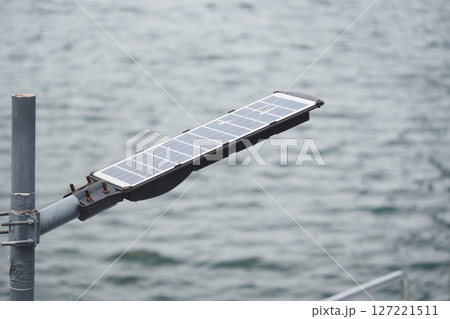 Solar panel installation beside calm waterway Solar panel installation beside calm waterway 127221511