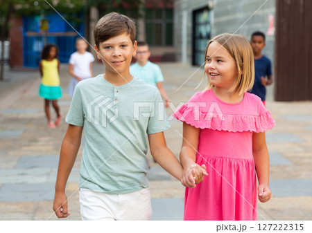 Boy and girl walking together hand in hand Boy and girl walking together hand in hand 127222315