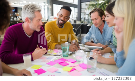 Team brainstorming ideas in an open office space during a collaborative workshop session 127222398