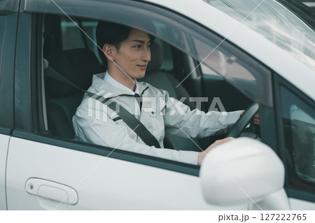 作業着にネクタイ姿の男性が車移動する 作業着にネクタイ姿の男性が車移動する 127222765