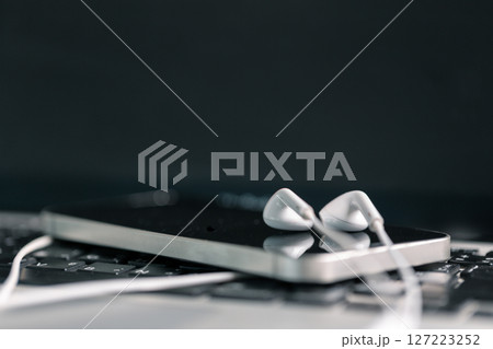 New technology modern Close up high resolution Wireless Earphones white Earbuds headphones black blur background Trendy minimal music device laptop concept phone accessories Comfortable Wooden table 127223252