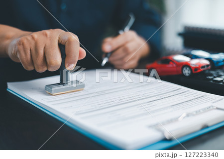 Businesswoman hand stamp approve on financial business approval document paper. Man hand accept permit contract agreement. Broker manager sign contract bank guarantee approved stamp application form 127223340