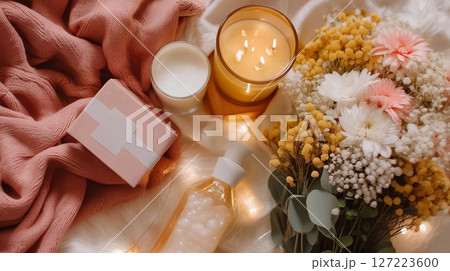 Relaxing evening setup with candles, flowers, and skincare products for self-care time 127223600