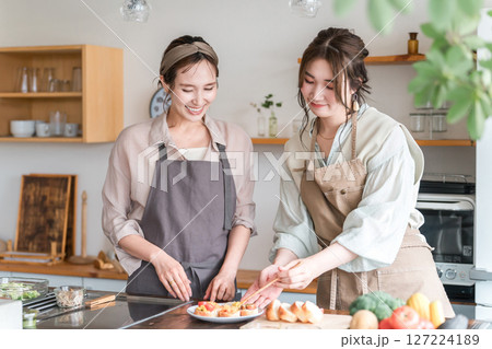料理教室・クッキングスクールで料理を教える講師の女性と生徒の女性 料理教室・クッキングスクールで料理を教える講師の女性と生徒の女性 127224189
