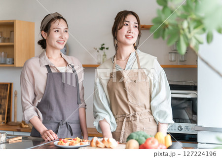 料理教室・クッキングスクールで料理を教える講師の女性と生徒の女性 127224196
