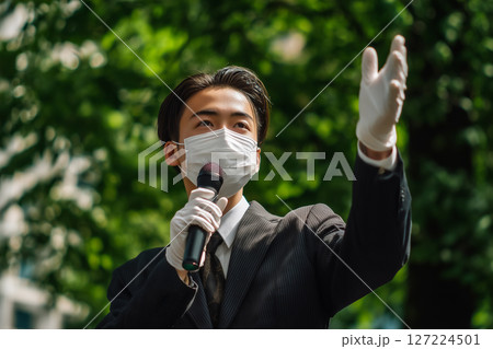 若い政治家が日差しと緑の中で演説、市民参加の概念を表現 127224501