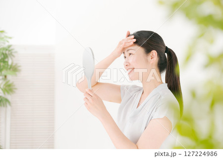 笑顔で鏡を見る女性 127224986