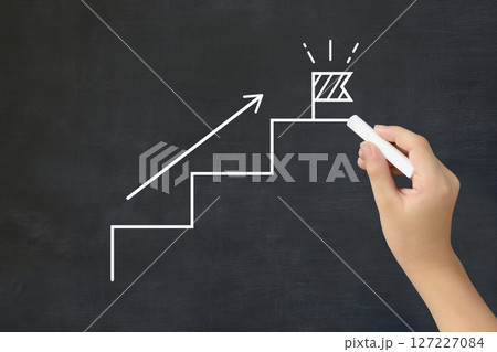 旗の建てられたステップを黒板に描く子どもの手 旗の建てられたステップを黒板に描く子どもの手 127227084