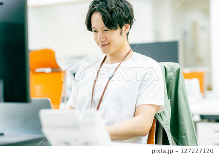パソコンに向かう若いビジネスマン パソコンに向かう若いビジネスマン 127227120