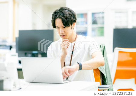 パソコンに向かう若いビジネスマン パソコンに向かう若いビジネスマン 127227122