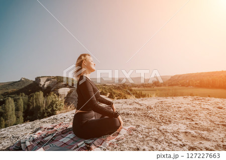 Woman Meditating on a Mountaintop 127227663