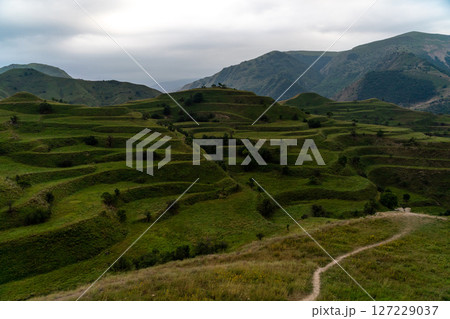 Chokhsky terraces Dagestan. Landscape of mountainous Dagestan with terraced fields and peaks mountains in the distance. Chokhsky terraces Dagestan. Landscape of mountainous Dagestan with terraced fields and peaks mountains in the distance. 127229037