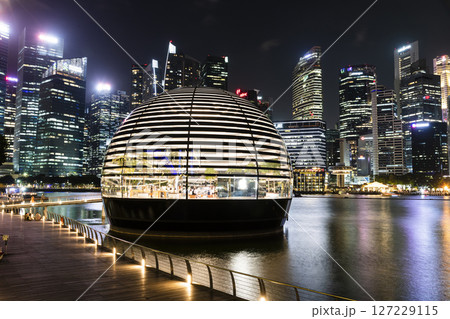 Night view of the Apple Marina Bay Sands with a skyscraper background, Singapore, is the first Apple store in the world surrounded by water. 127229115