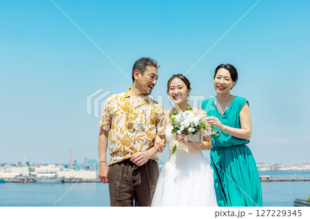 記念撮影をする新婦と両親 127229345