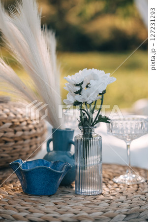 Beautiful floral arrangement on a picnic table in a sunny outdoor setting 127231293