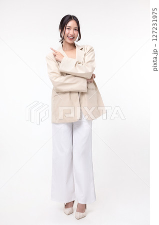 Happy Asian business woman in blazer pointing finger isolated on white background. 127231975