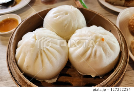 Soft and Steamed Buns in Traditional Bamboo Steamer Basket 127232254