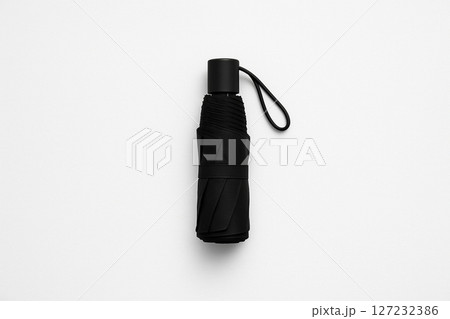 白い背景に置かれたシンプルな黒い折りたたみ傘 白い背景に置かれたシンプルな黒い折りたたみ傘 127232386