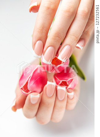Woman showing french manicure holding pink tulips 127232561