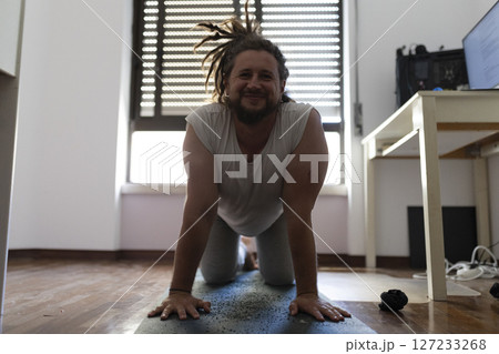 Freelancer doing yoga on mat in home office Freelancer doing yoga on mat in home office 127233268