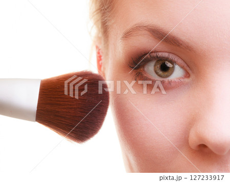 Part of woman face applying rouge blusher makeup detail. 127233917