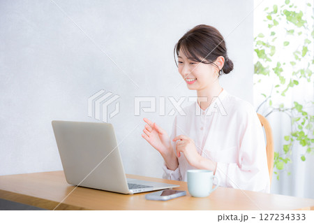 webでオンライン会議をするパソコンを作業する女性 127234333