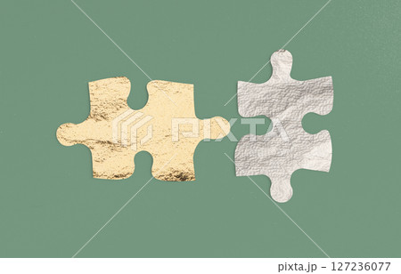 Two puzzle pieces connecting, symbolizing partnership and teamwork. A perfect fit representing Two puzzle pieces connecting, symbolizing partnership and teamwork. A perfect fit representing 127236077