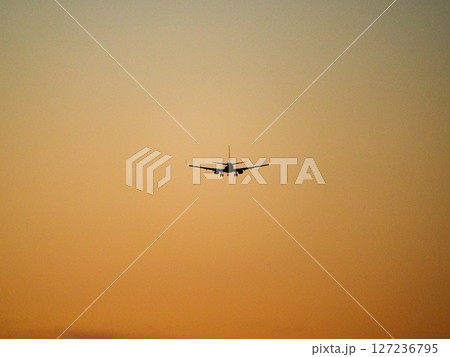 茜色の空の中を飛ぶ飛行機 茜色の空の中を飛ぶ飛行機 127236795
