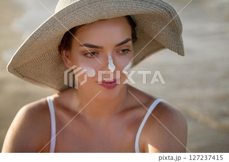 Skin care. Sun protection. Beautiful Woman In Bikini apply sun cream on Face. Woman With Suntan Lotion On Beach. Portrait Of Female With Moisturizing Sunblock.The Girl Uses Sunscreen for Her Skin Skin care. Sun protection. Beautiful Woman In Bikini apply sun cream on Face. Woman With Suntan Lotion On Beach. Portrait Of Female With Moisturizing Sunblock.The Girl Uses Sunscreen for Her Skin 127237415