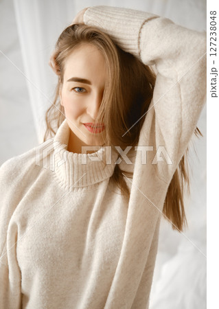 Close-up portrait of a young woman in cozy sweater Close-up portrait of a young woman in cozy sweater 127238048