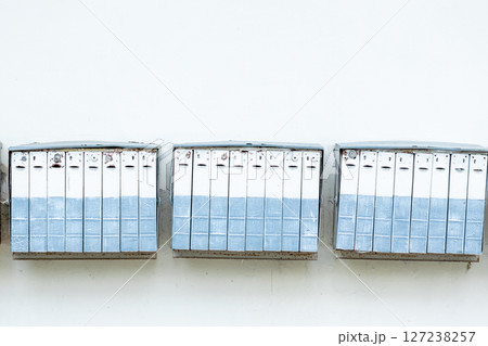 Very old mail boxes hanging on white wall 127238257