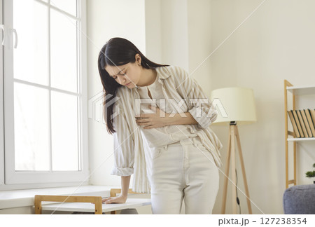 Unhealthy stressed young woman, girl feeling pain ache touching chest having heart attack Unhealthy stressed young woman, girl feeling pain ache touching chest having heart attack 127238354