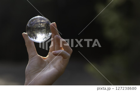 Hand holding transparent glass globe, symbolizing the protection and conservation of Earth. Hand holding transparent glass globe, symbolizing the protection and conservation of Earth. 127238680