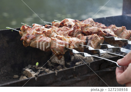 closeup of some meat skewers being grilled in a barbecue 127238938