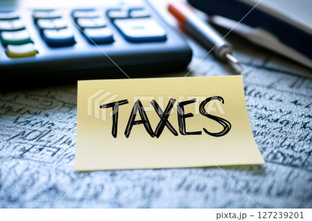 Word 'taxes', calculator and finance paperwork. Taxes text written on a paper sticker. Financial calculations. Paying taxes receipts online, planning budget. Chance for economy saving money, audit 127239201