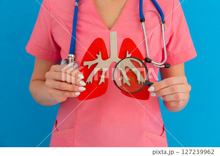 Female doctor showing anatomical model of human lung using magnifying glass. Early diagnosis and treatment 127239962