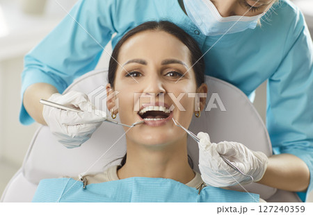 Dentist Checking Woman Patient Oral Care In Clinic 127240359