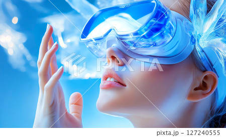 Woman wearing vr glasses interacting with virtual reality touching something with her hand on a blue background 127240555