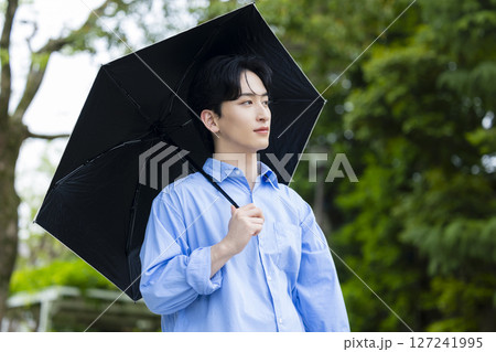 日傘を差す若い男性 127241995