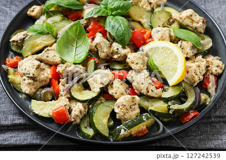 baked italian chicken and vegetables on a plate baked italian chicken and vegetables on a plate 127242539