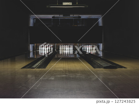 Old and dark parquet bowling track with white pins 127243825